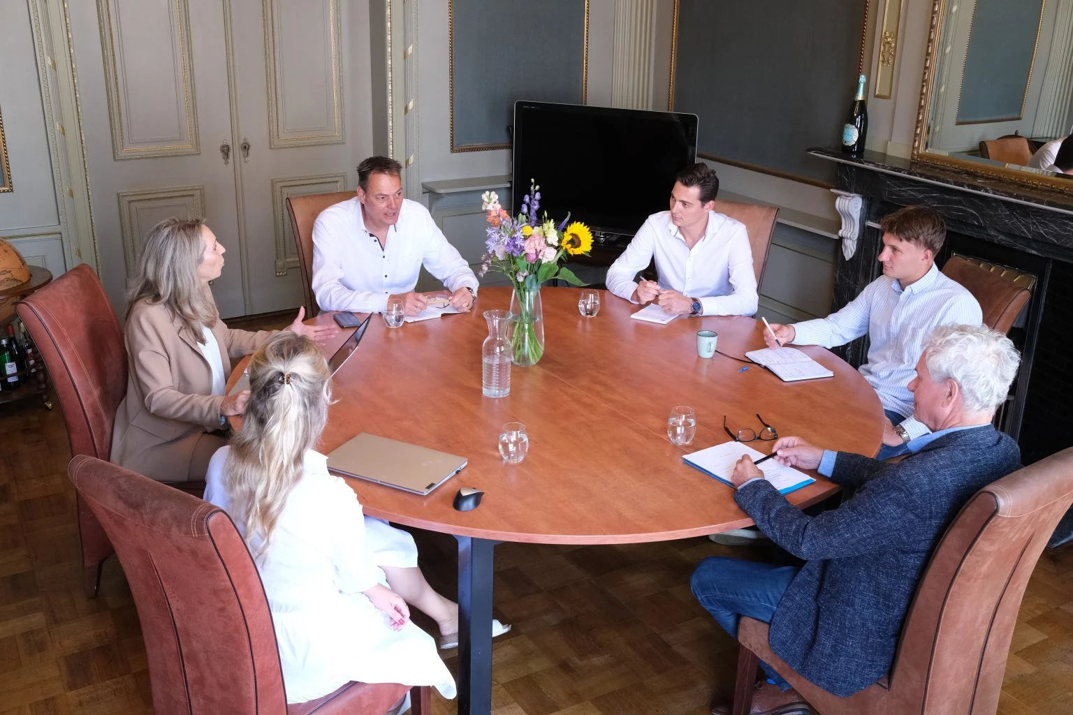 Overleg met notarissen en compliance officers aan een ronde tafel